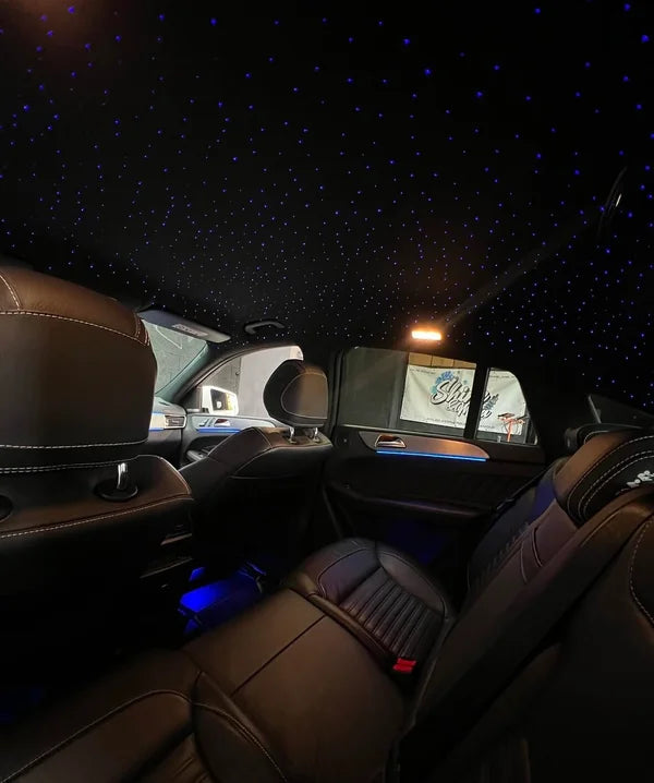 Ciel étoilé LED dans l’habitacle d’une voiture avec sièges en cuir noir.