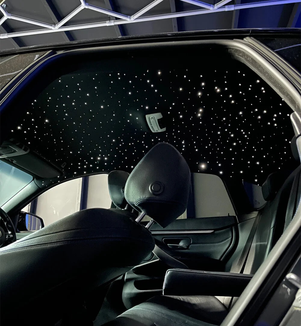 Intérieur de voiture avec ciel étoilé lumineux personnalisable, ambiance haut de gamme.
