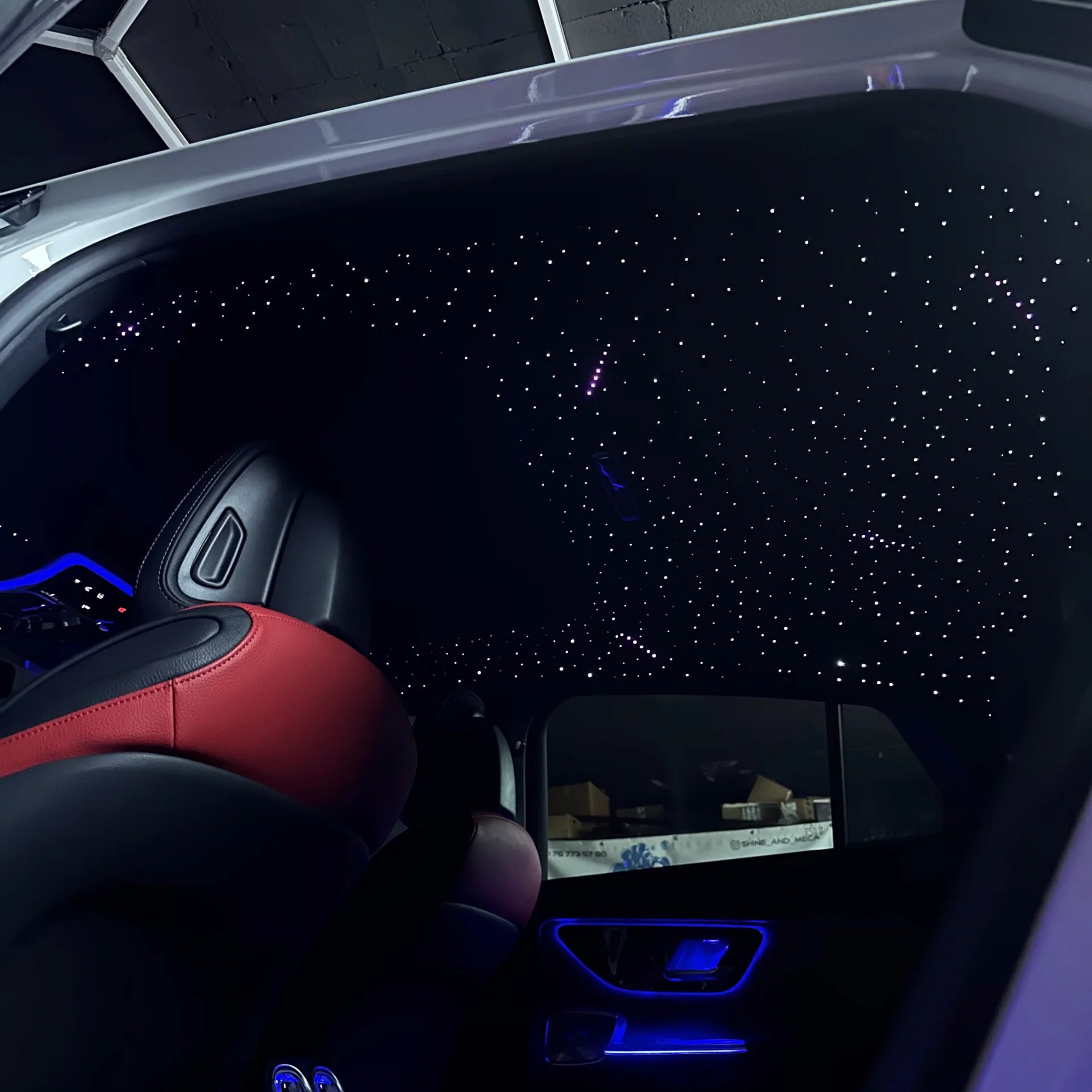 Toit étoilé en fibre optique dans l’habitacle d’une voiture de luxe, ambiance lumineuse personnalisée.